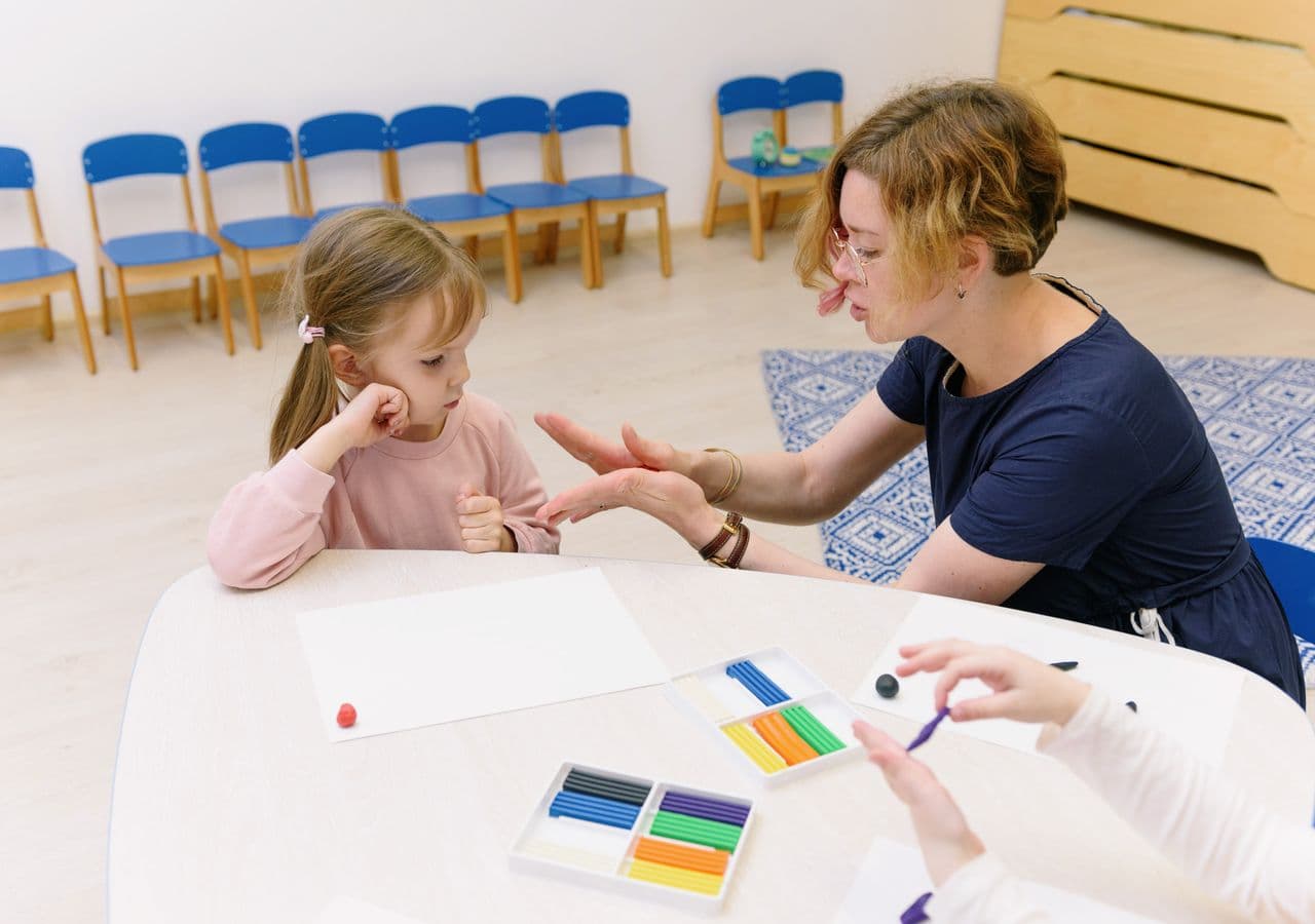 Educator and children playing with building blocks at a childcare center